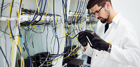 Man plugging wifi router in with a bunch of wires around