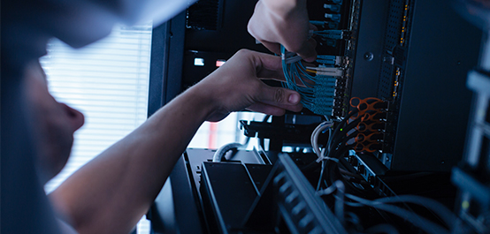 Person fixing wires on server