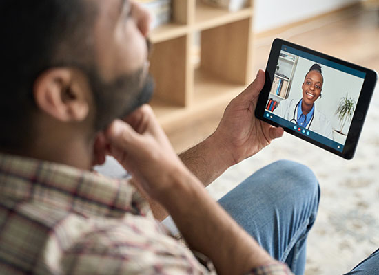Man having virtual healthcare services with doctor on tablet
