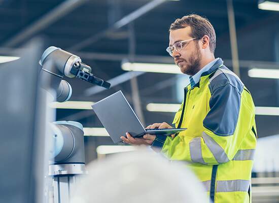 Man in safety jacket looking at laptop