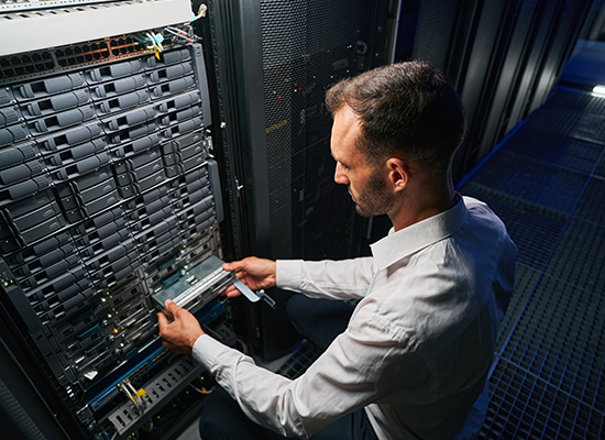 Man fixing computer server in server room