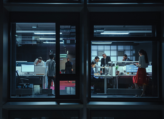 Several business people working around a cubicle